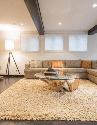 Modern living room with sectional sofa, shag rug, and wooden accents.