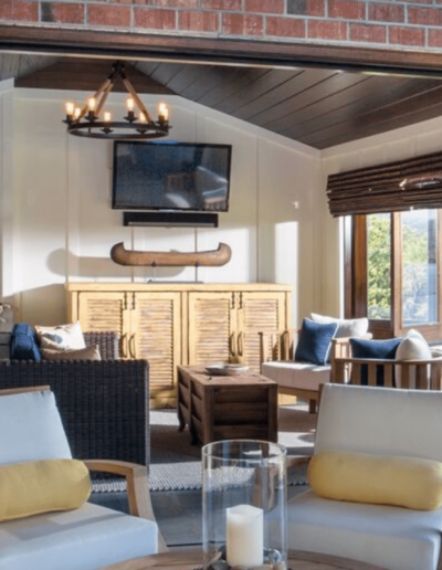 Cozy living room interior with a mix of modern and rustic design elements, featuring comfortable seating, a television, and warm lighting.