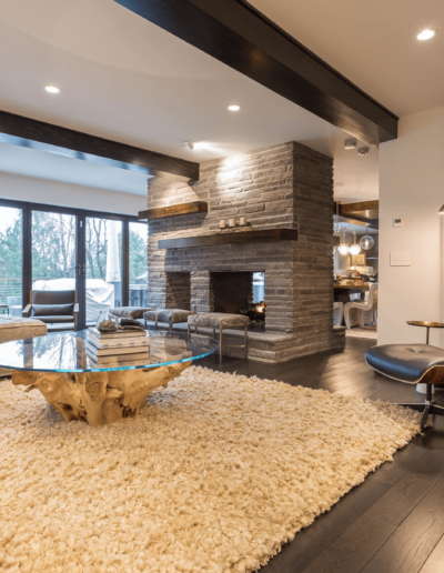 Elegant modern living room with stone fireplace, hardwood floors, and contemporary furniture.