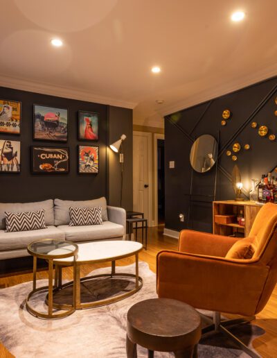 Elegantly furnished living room with dark walls, patterned decor, and gold accents.